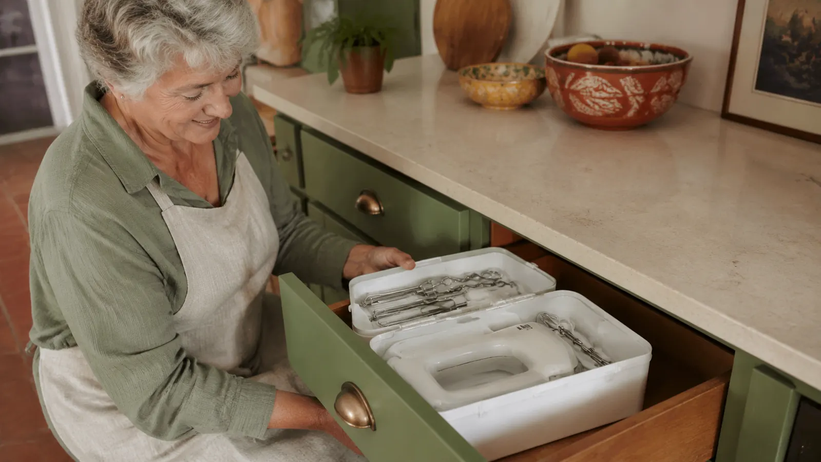 Snap-on storage case for the hand mixer tucked into a kitchen drawer beside beaters and whisk attachment
